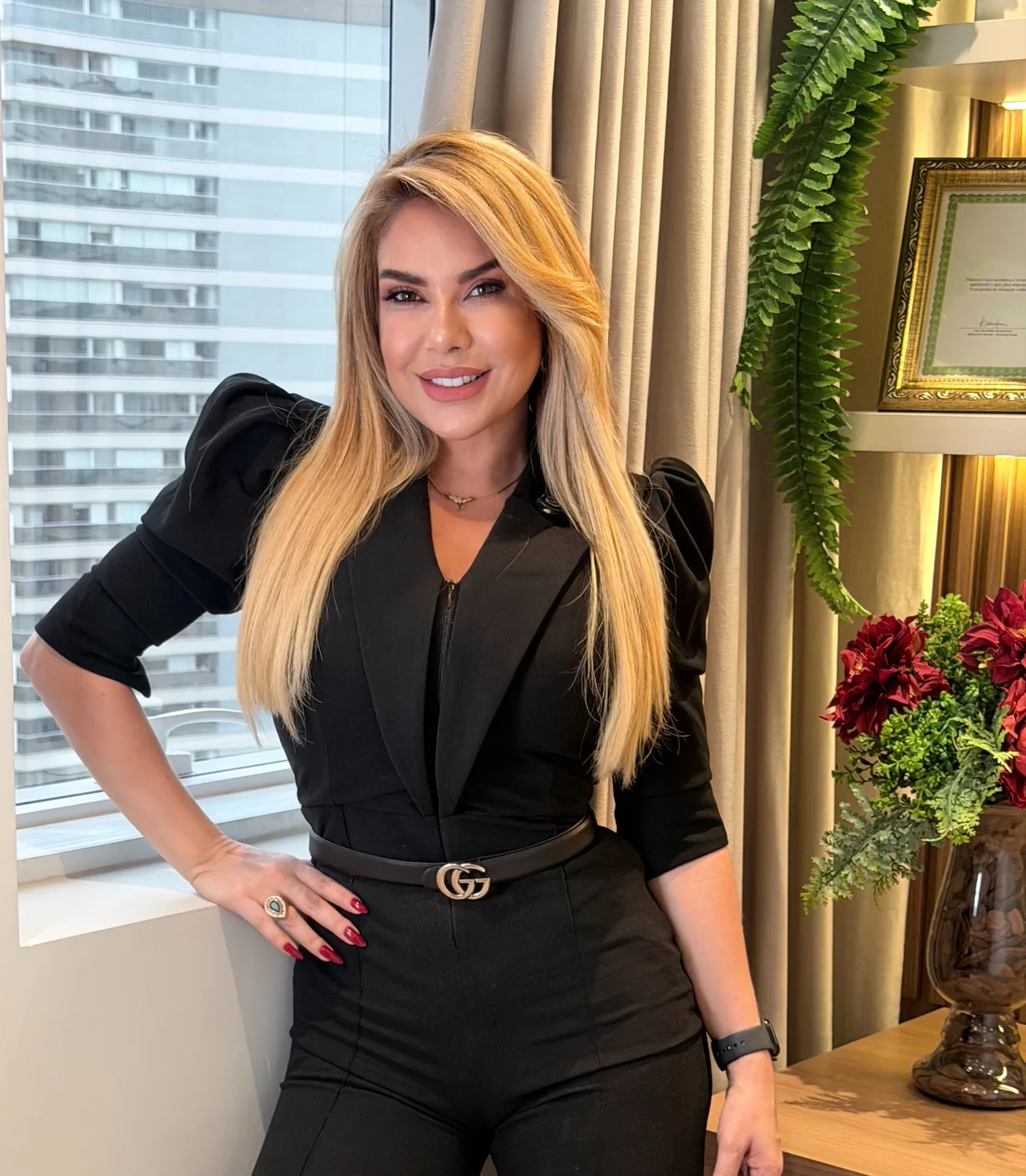 Dra. Gil Jung em pé ao lado da janela do consultório.